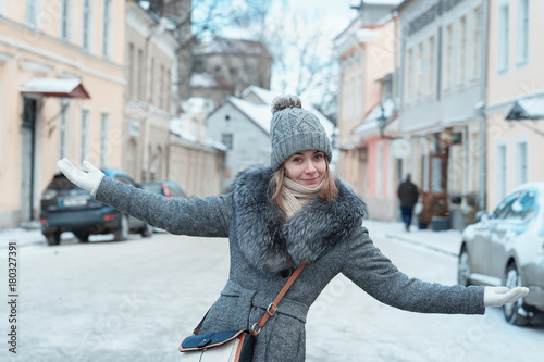 Happy cheerful woman with wide open arms outside on a winter day
