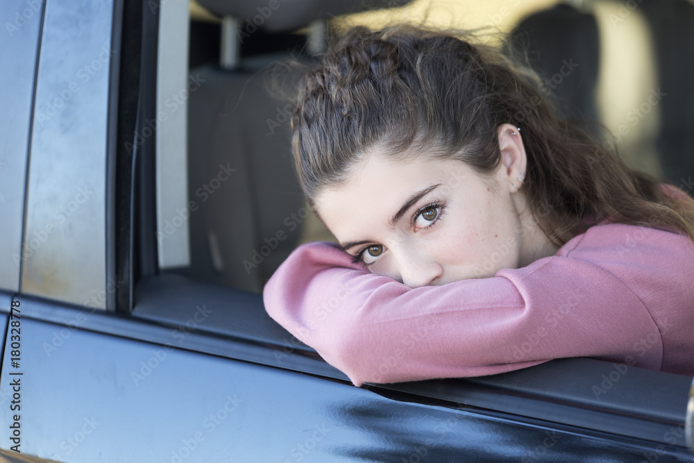 Teenage girl looking out the window of her car Teenage girl looking out the window of her car
