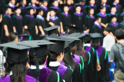 Back of graduates during commencement at university. Close up at graduate cap