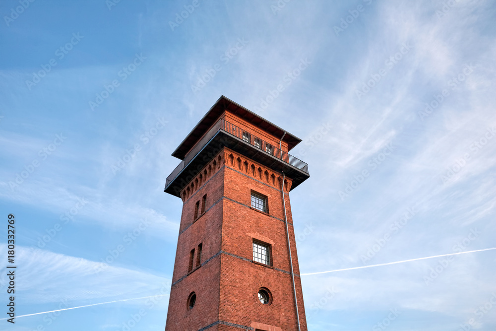 Old Brick Tower at Sunset, under a cloudy blue sky