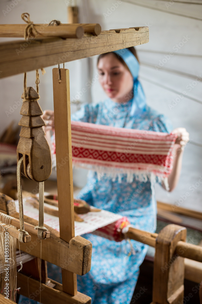 Φωτογραφία The woman is weaving the colorful cotton robe or dress by using wooden loom in t