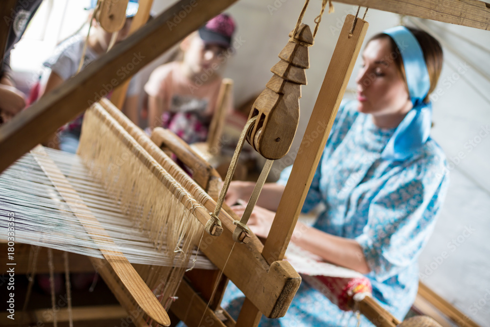 Φωτογραφία The woman is weaving the colorful cotton robe or dress by using wooden loom in t