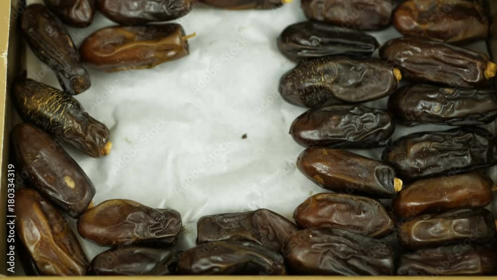 Hand taking out dates fruit in the package. People taking dates out of carton. Hand taking out dates fruit in the package. People taking dates out of carton.