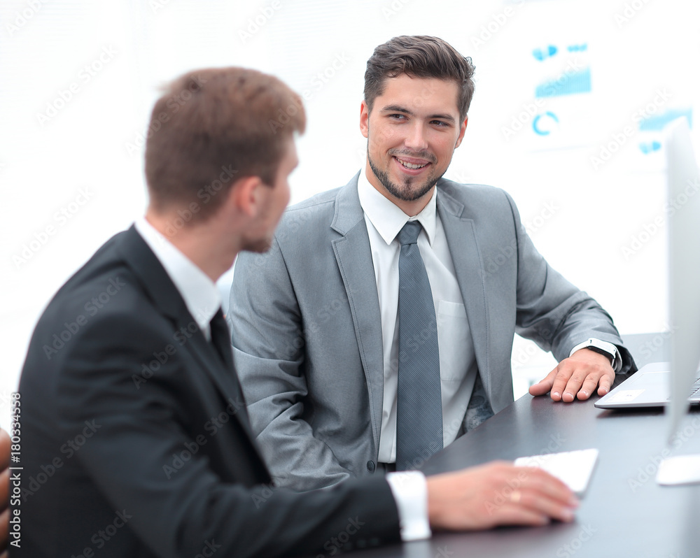 Manager with the colleague sitting at the Desk Manager with the colleague sitting at the Desk