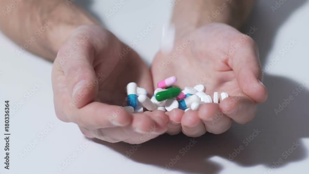 Various pills falling into hands of person, pharmaceutical industry, medication