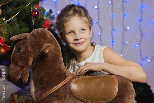 девочка сидит с лошадкой-качалкой