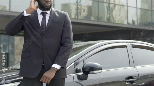 Serious bodyguard of official carefully examining situation, looking around
