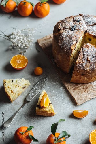 Panettone, traditional Italian Christmas cake. Close-up with slice and oranges.
