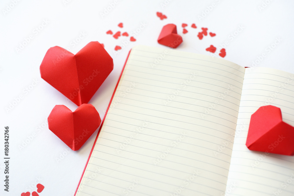 Red Paper hearts of origami with a notebook on a white background