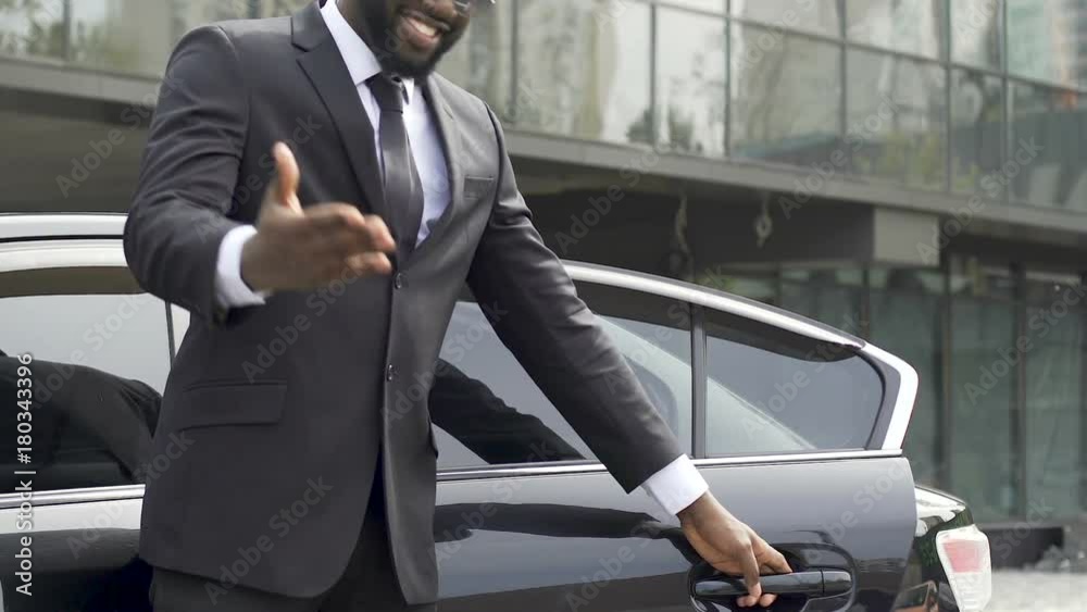 Luxury taxi driver opening door for wealthy client, inviting for ride, services
