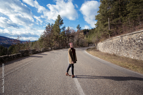 girl hipster stands on a mountain road