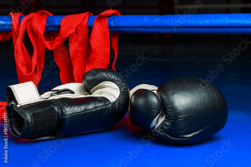 Boxing gloves and elastic bandage lying on the floor of the ring after a workout