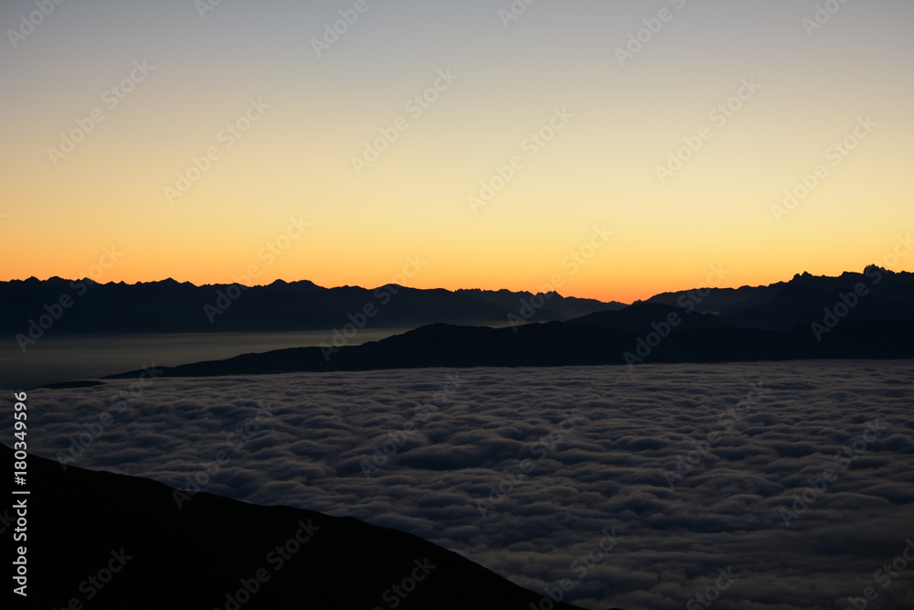wolkenmeer im sonnenaufgang in südtiroler bergen