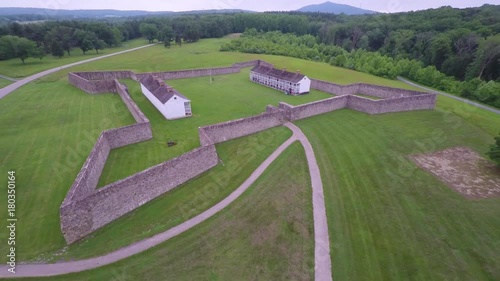 Aerial of the Calvert Arms/King’s Colors flag waving in the breeze with the barracks in the distance at Fort Frederick in Maryland. photo