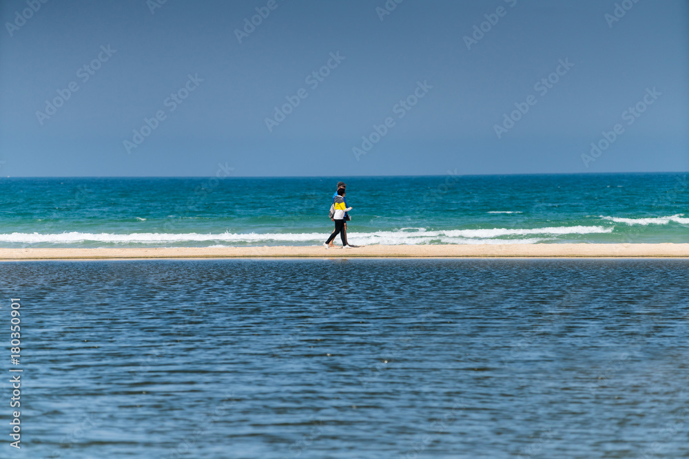 people walking along the seashore