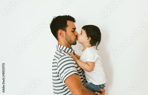 Portrait of handsome father kissing his little daughter. Young dad is enjoying time with his child. Handsome father with little girl. Happy father and daughter. Lifestyle family.