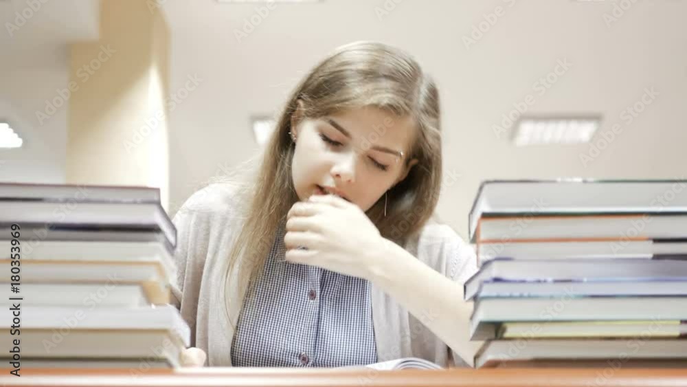 Female student falls asleep after been reading and studying all day in the library Female student falls asleep after been reading and studying all day in the library