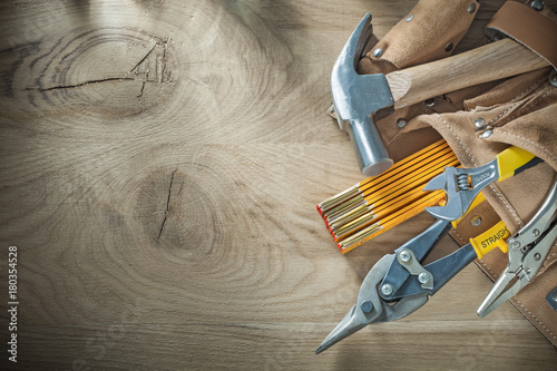 Canvas Print Leather building belt with construction tooling on wooden board