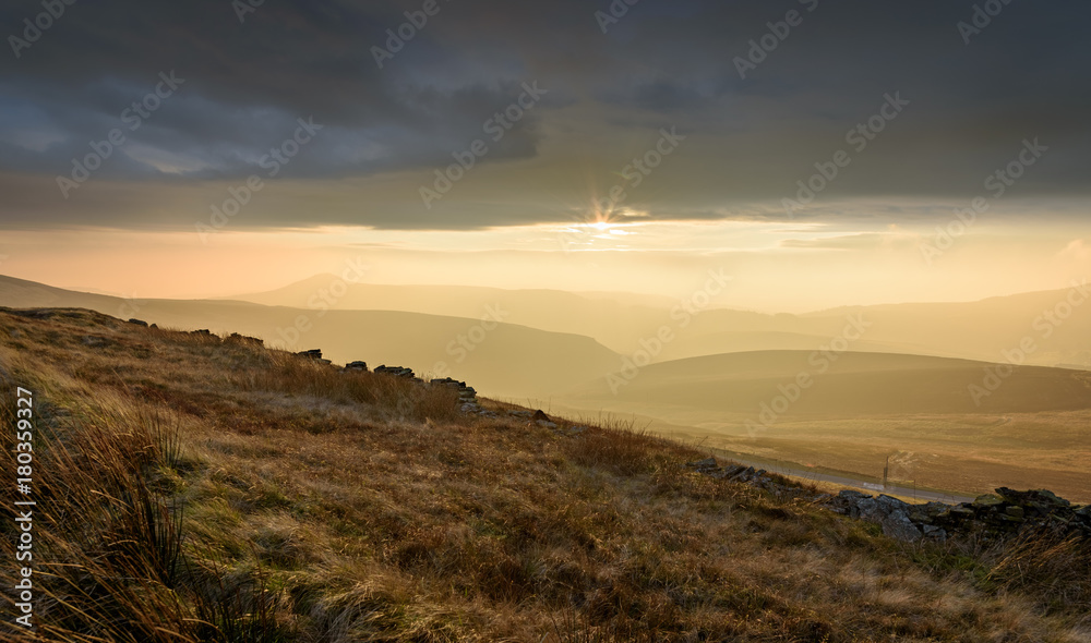 Beautiful autumn scenery in the Peak District - layers of hills and sunlight with dramatic clouds hanging over Beautiful autumn scenery in the Peak District - layers of hills and sunlight with dramatic clouds hanging over
