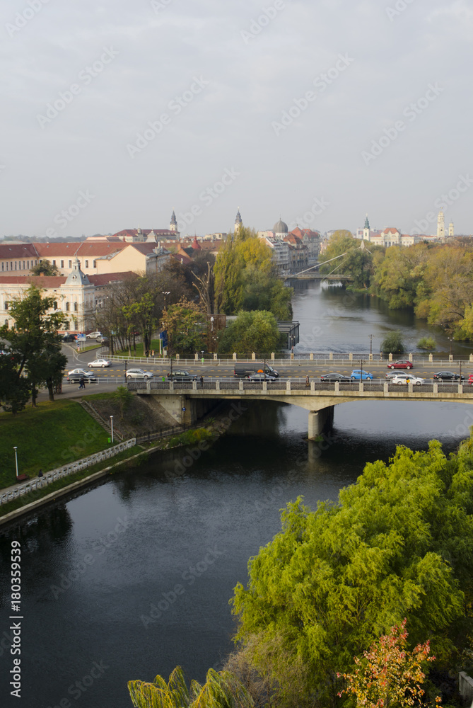 Bridge over river and autumn colored trees on the shore in historical city