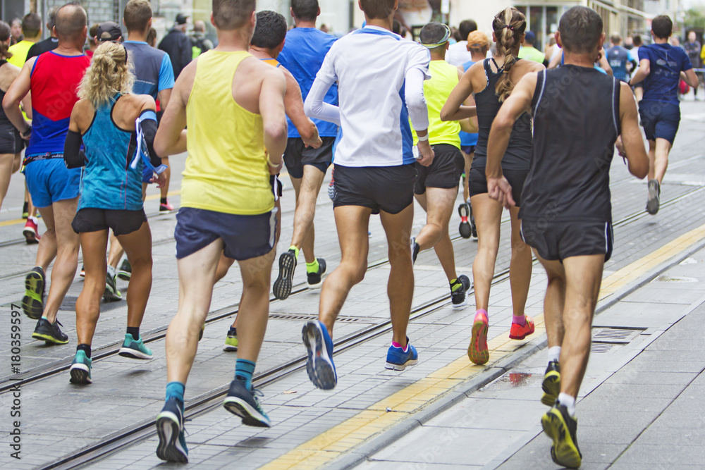 Marathon runners race in city streets, blurred motion