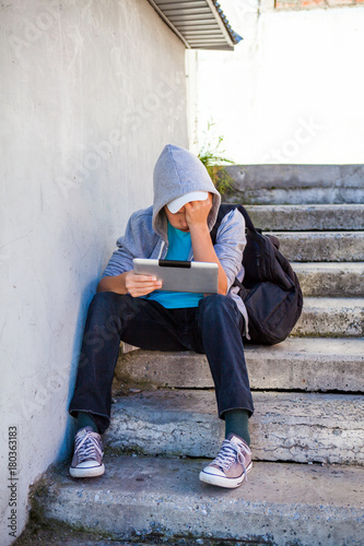 Sad Teenager with a Tablet © Sabphoto