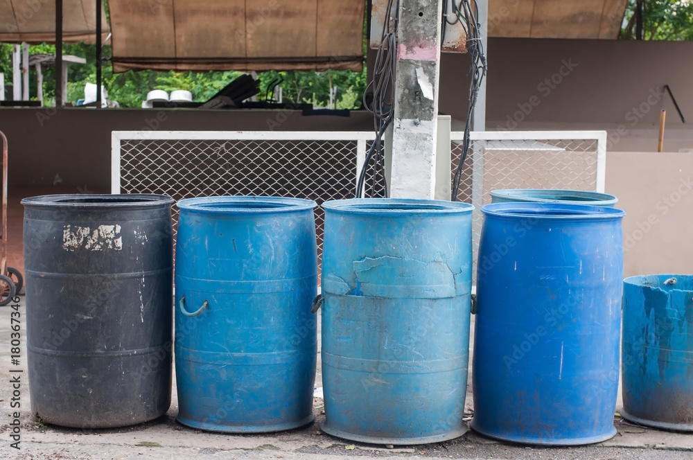 Black and blue plastic bins next to electric pole. Black and blue plastic bins next to electric pole.
