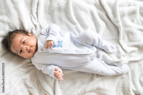 Cute asian baby liyng on bed