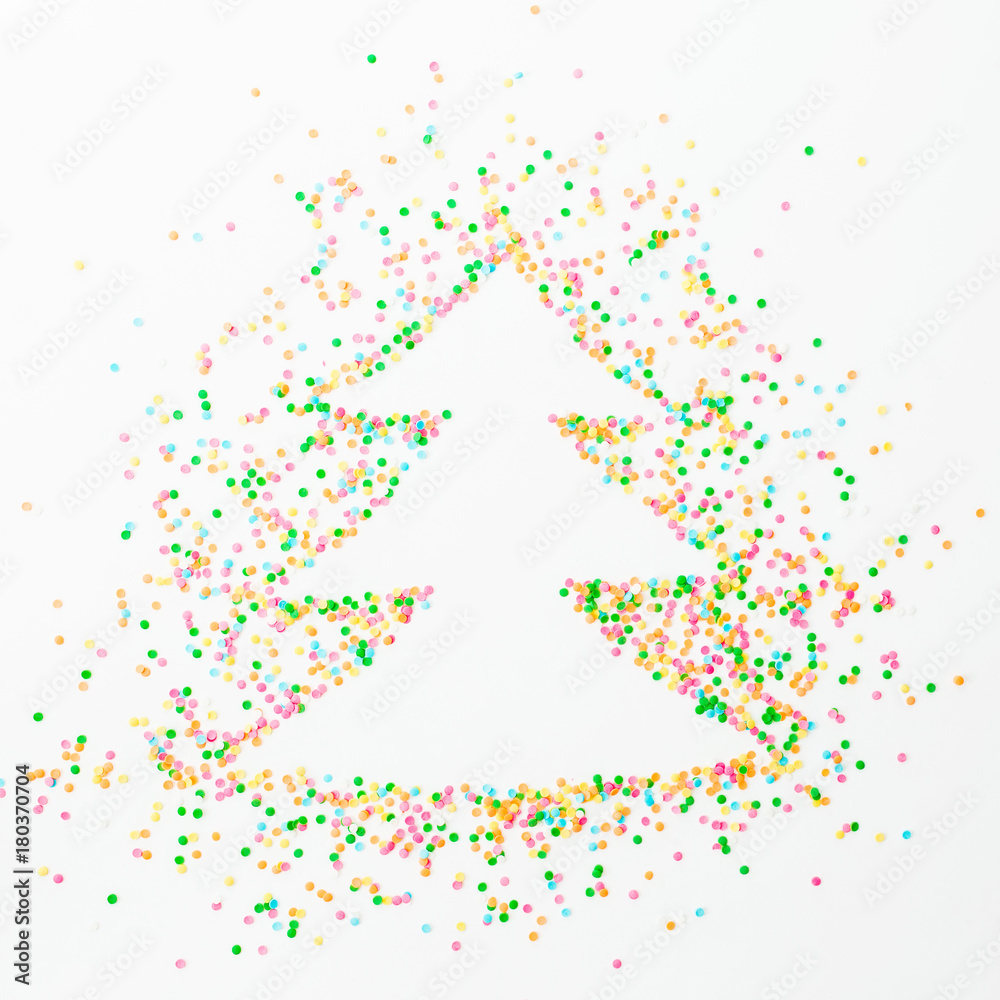 Christmas tree made of colorful bright confetti on white background. Flat lay, top view copy space Christmas tree made of colorful bright confetti on white background. Flat lay, top view copy space