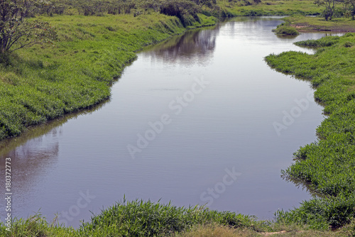 A river running quietly among green field