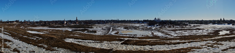 Panorama of the city of Suzdal from a bird's eye view/Panorama of Suzdal from the air. Houses, temples, streets, trees are visible. In the yards lies snow. Suzdal. Golden Ring of Russia
