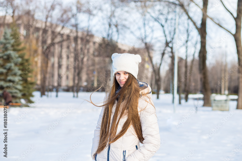 Portrait of a beautiful girl in white with very long hair in a snowy winter. Winter lifestyle portrait of beautiful girl walking in the snowy park Portrait of a beautiful girl in white with very long hair in a snowy winter. Winter lifestyle portrait of beautiful girl walking in the snowy park