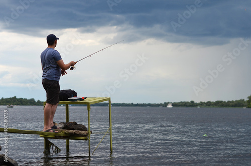 fisherman is fishing on the river bank