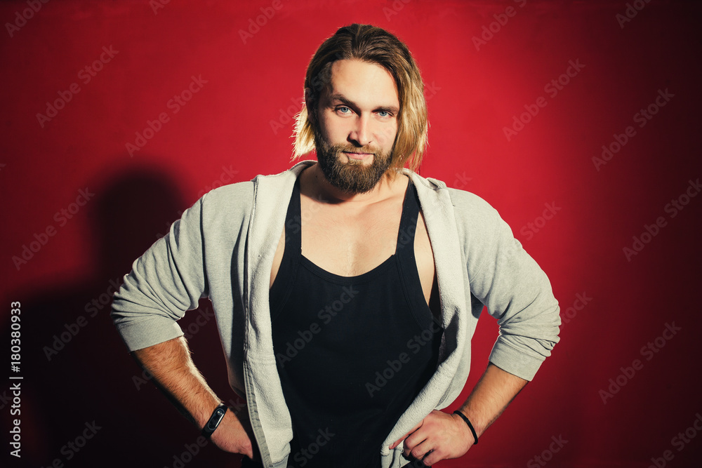 pumped-up man with a beard on a red background