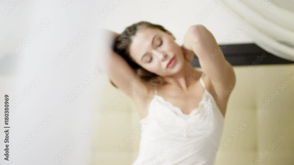 Young attractive woman showing herself in sexual poses on bed in white sleepwear Young attractive woman showing herself in sexual poses on bed in white sleepwear
