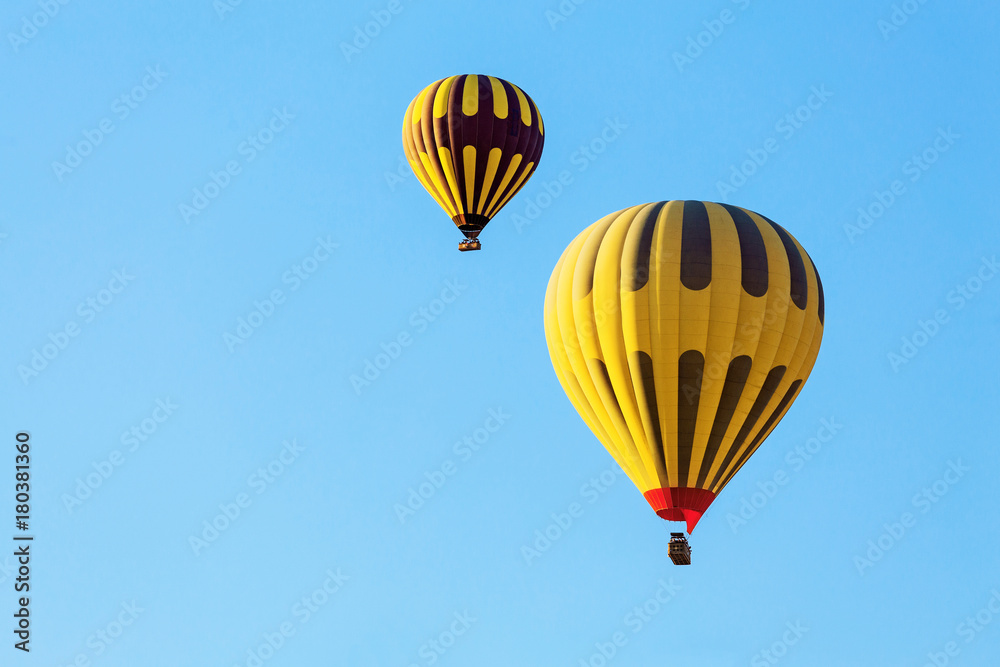 Many unrecognizable colorful hot air balloons against blue sky Many unrecognizable colorful hot air balloons against blue sky