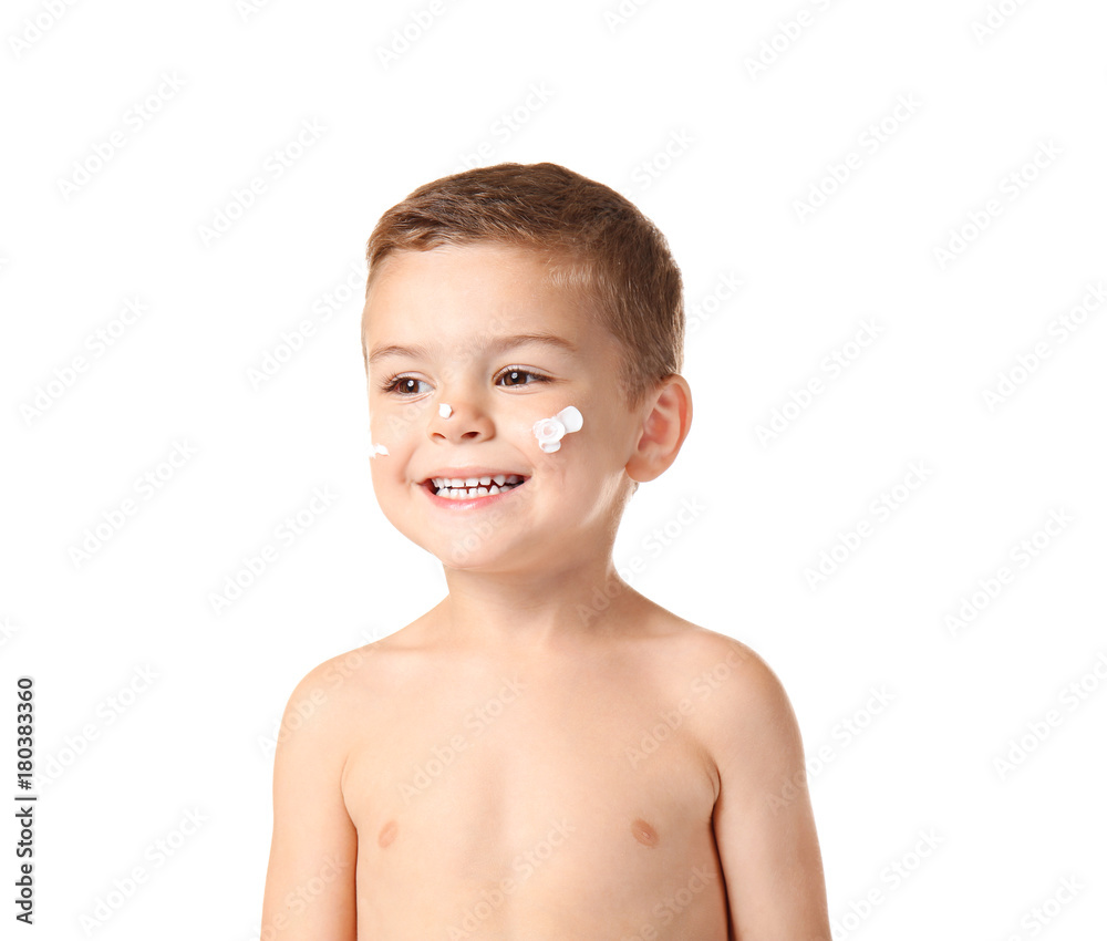 Cute little boy with suntan cream on his cheeks against white background