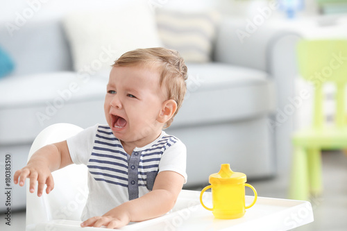 Tablou canvas Adorable crying baby sitting in highchair at home