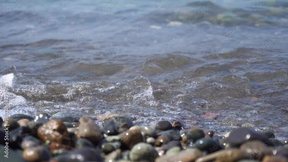 Sea pebbles and ocean waves on the beach. Close-up. Sea pebbles and ocean waves on the beach. Close-up.