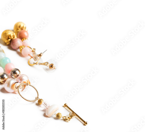 gold jewerly braslete and earrings with semiprecious at white background photo