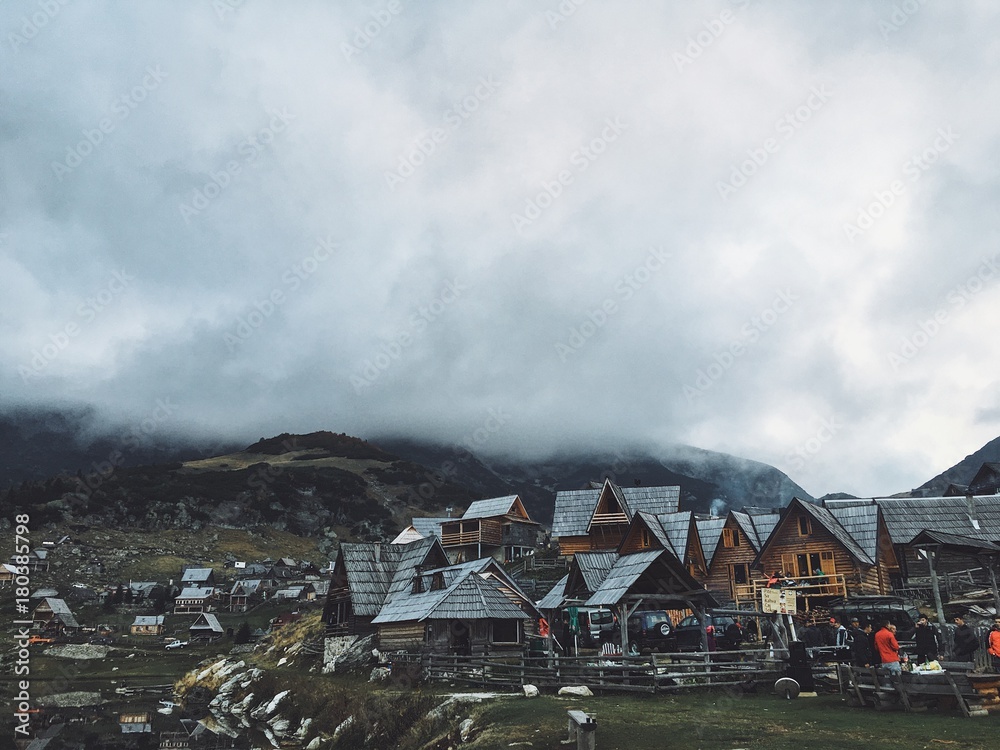 Fototapeta premium misty mountains over village on cold autumn day