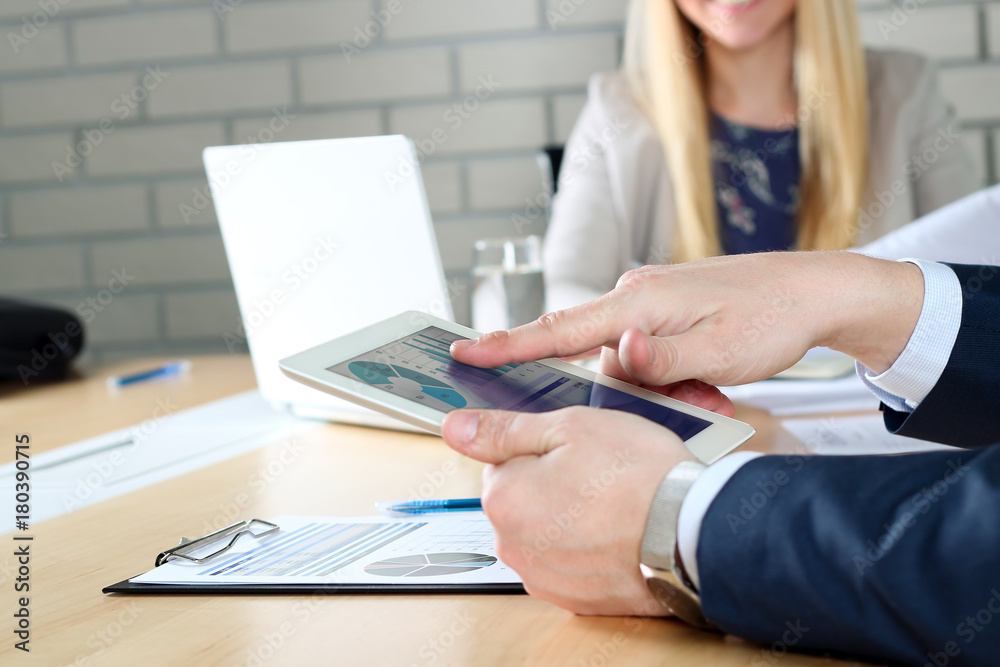business colleagues working together and analyzing financial figures on a digital tablet