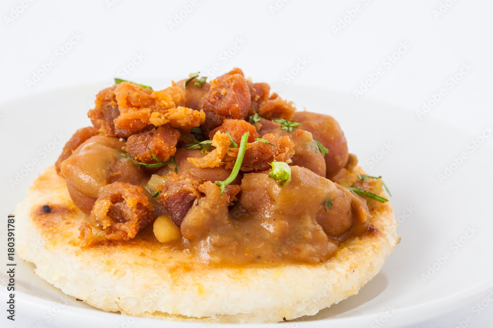 Traditional Colombian arepa topped with beans and pork rind Traditional Colombian arepa topped with beans and pork rind