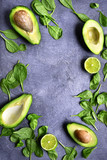 Avocado halves with baby spinach leaves and lime.Top view with copy space.