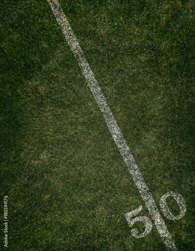 Football field ground fifty yard line. Friday night lights.