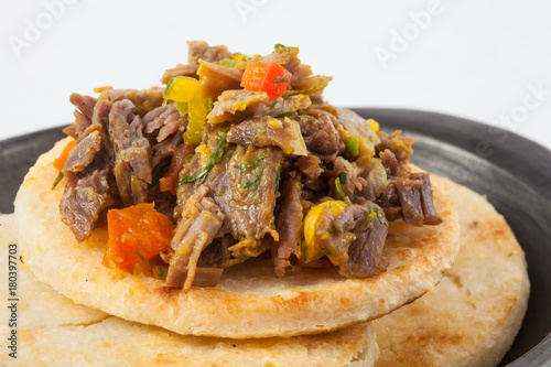 Traditional Colombian arepa topped with shredded beef