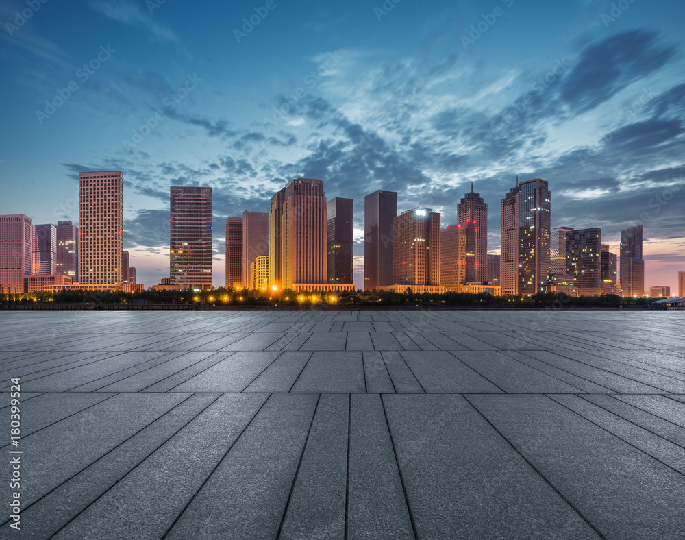 night view of empty pavement front of cityscape and skyline