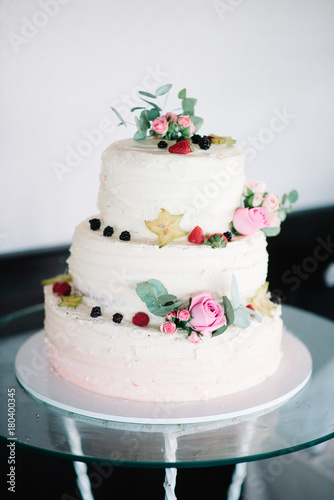 beautiful white wedding cake with flowers and fruits berries