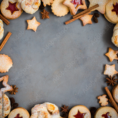 Ginger homemade cookies with strawberry jam on gray concrete background with Christmas tree. View with copy space. Flat lay, top view. Christmas Border - horizontal banner. Web size. stars.