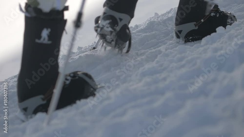 Tourist people in crampons walking on snow trail in mountain close up